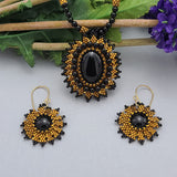 Handmade necklace and earrings set with a black onyx centerpiece and gold bead embroidery, perfect for formal occasions