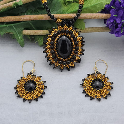 Handmade necklace and earrings set with a black onyx centerpiece and gold bead embroidery, perfect for formal occasions