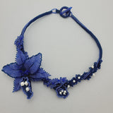 Luxury handmade jewelry with blue beads and floral design.