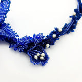 Luxury handmade jewelry with blue beads and floral design.