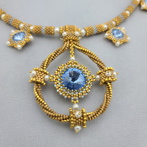 <img src="blue-sapphire-necklace.jpg" alt="Handmade Blue Sapphire Rivoli necklace with freshwater pearls and gold-plated seed beads">
